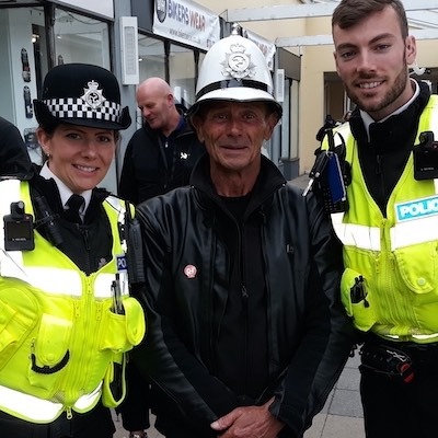 Motard avec le sourire encadré par des policiers sur l'île de Man