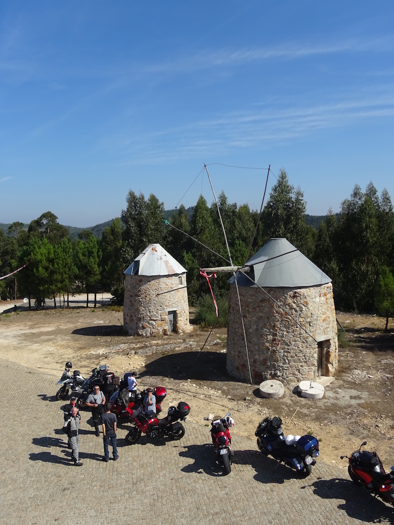 Groupe de motards a l arret devant deux moulins de pierre dans un village du Portugal
