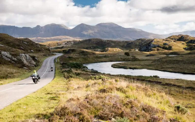 Deux motos sur une route des Highlands écossais, loch et montagnes en arrière-plan
