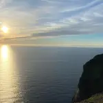 La falaise du Cap Nord plongeant dans la mer de Barents, le globe au bord du plateau, sous le soleil de minuit